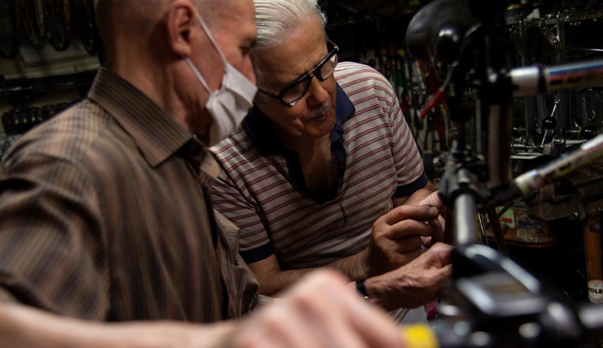 Raffaello Bianco, mekanik dan pecinta sepeda bekerja di bengkel mekaniknya di ruang bawah tanah apartemennya di Turin, Italia, 7 Juli 2020. Pada tahun 1985 Raffaello Bianco memutuskan untuk mendirikan sebuah garasi kecil dekat rumahnya di Turin dan membangunnya perlahan-lahan. (MARCO BERTORELLO/AFP)