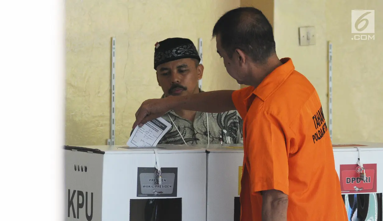 Tahanan memasukkan surat suara ke dalam kotak usai mencoblos di TPS 15 Rutan Polda Metro Jaya, Jakarta, Rabu (17/4). Sebanyak 538 tahanan di Rutan Polda Metro Jaya yang telah terdaftar dalam DPT ikut menyuarakan aspirasinya dalam Pemilu 2019. (Liputan6.com/Herman Zakharia)