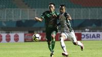 Gelandang PSMS Medan, Frets Butuan, berebut bola dengan gelandang PS Tira, Manahati Lestusen, pada laga Liga 1 di Stadion Pakansari, Jawa Barat, Rabu (5/12). PSMS kalah 2-4 dari PS Tira. (Bola.com/Yoppy Renato)