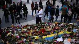 Orang-orang berkerumun di lokasi terjadinya serangan truk di Stockholm, Swedia, Minggu (9/4). Sebuah truk yang dibajak menabrakkan diri ke kerumunan pejalan kaki pada Sabtu (8/4) dan menewaskan empat orang. (AP Photo / Markus Schreiber)