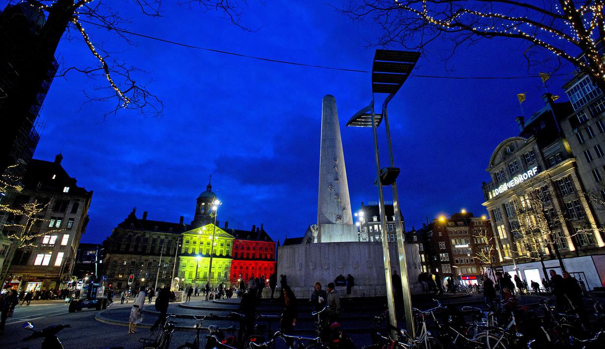 Proyeksi gambar bendera Belgia (hitam, kuning, dan merah) terlihat di Royal Palace di Dam Square, Amsterdam, Selasa (22/3). Hal itu sebagai bentuk penghormatan terhadap korban serangan bom Brussels. (Evert Elzinga/ANP/AFP)