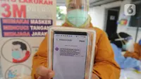 Paramedis menunjukkan SMS undangan mengikuti kegiatan vaksin Covid-19 di Puskesmas  Ciganjur, Jakarta Selatan, Kamis (7/1/2021). Direncanakan pelaksanaan vaksin Covid-19 pada 14 Januari besok dengan prioritas bagi para tenaga kesehatan. (merdeka.com/Arie Basuki)