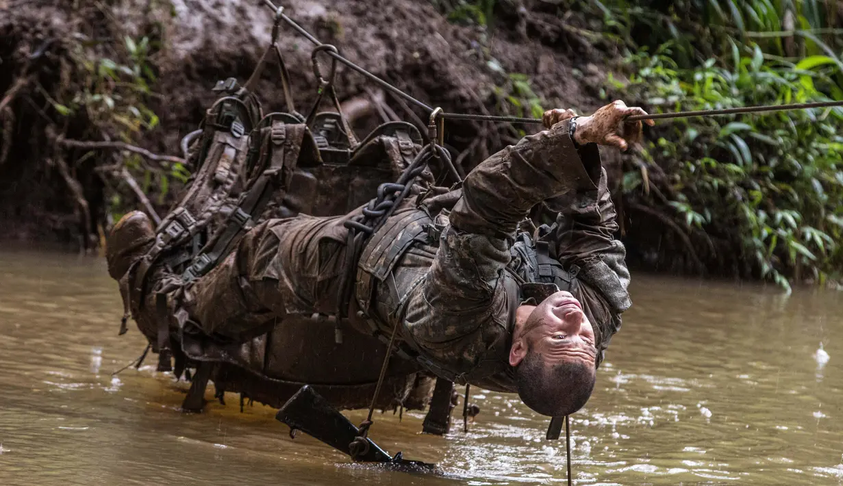 Tentara dari Combat Team Divisi Infanteri 1 Stryker Brigade Angkatan Darat AS melintasi sungai dengan tali dalam pelatihan perang hutan di Hawaii, 1 Maret 2017. Tentara melakukan kursus pelatihan hutan untuk fokus pada Asia dan Pasifik. (AP/Daniel Lin)