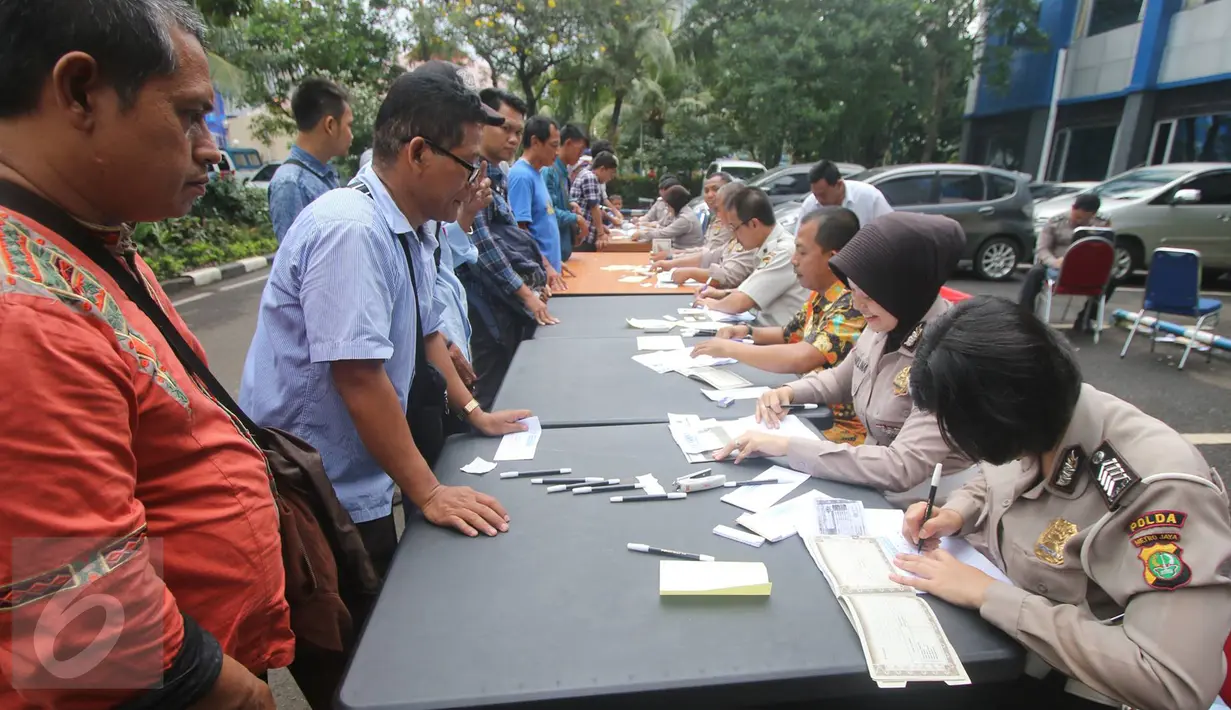 Petugas mendata pengurusan BPKB di Gedung Biru Ditlantas Polda Metro Jaya, Jakarta, Kamis (5/1). Antrean tersebut terjadi jelang kenaikan biaya PNBP (penerimaan negara bukan pajak) dalam pengurusan administrasi kendaraan. (Liputan6.com/Immanuel Antonius)