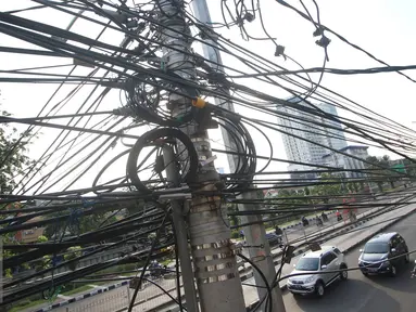 Instalasi kabel saling bersinggungan di tiang Jalan Gunung Sahari, Jakarta, Rabu (13/7). Kurangnya penataan membuat instalasi kabel di Ibu Kota terlihat semrawut dan mengganggu pemandangan. (Liputan6.com/Immanuel Antonius)