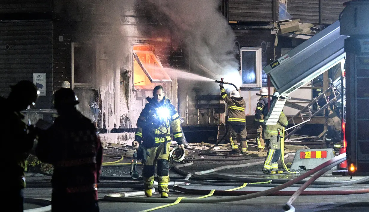 Sebuah tempat pengungsi di Fagersjo terbakar, Stockholm, Swedia pada Minggu (16/10) malam. Petugas pemadam kebakaran berusaha memadamkan api yang berkobar dari dalam gedung. (REUTERS/TT News Agency / Johan Nilsson)