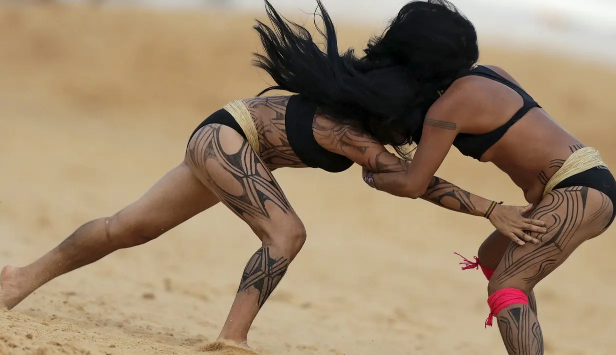 Dua wanita adat sedang bergulat dalam pertandingan yang disebut Huka Huka pada Olimpiade bagi Masyarakat adat, Palmas, Brasil, (30/10/2015). Masyarakat adat dari 22 negara di dunia ikut memeriahkan acara ini. (REUTERS/Ueslei Marcelino)