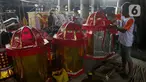 Perajin membuat replika barang-barang untuk sembahyang yang terbuat dari kertas di Kolong Tol Gedong Panjang, Jakarta, Senin (20/1/2025). (Liputan6.com/Herman Zakharia)