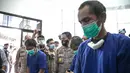 Tersangka kasus pemalsuan surat hasil rapid test COVID-19 dihadirkan dalam rilis di Mapolres Jakarta Pusat, Minggu (20/12/2020). Polisi menangkap tiga tersangka beserta bukti uang hasil transaksi pemalsuan surat hasil rapid test COVID-19. (Liputan6.com/Faizal Fanani)