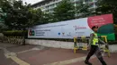 Seorang anggota kepolisian melintas di depan spanduk KAA di kawasan Senayan, Jakarta, Senin (20/4/2015). Pengamanan dilakukan untuk menjaga kelancaran KAA yang berlangsung 19-24 April 2015 di Jakarta dan Bandung. (Liputan6.com/Faizal Fanani)