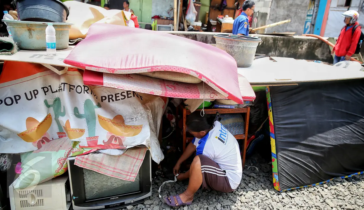 Warga duduk di dekat barang-barangnya yang berhasil diselamatkan dari kebakaran yang melanda pemukiman di Kampung Bandan, Ancol, Jakarta, Selasa (26/1). Api dengan cepat menjalar rumah warga yang terbuat dari kayu atau bedeng. (Liputan6.com/Faizal Fanani)