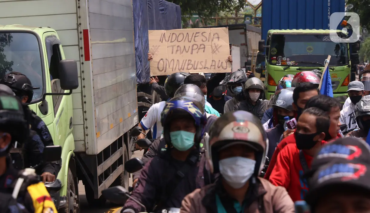 Buruh membawa spanduk saat konvoi di Kota Tangerang, Banten, Selasa (6/10/2020). Dalam aksi tersebut mereka menolak UU Omnibus Law Cipta Kerja yang sudah disahkan oleh DPR RI. (Liputan6.com/Angga Yuniar)