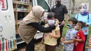 Karyawan Askrindo memberikan masker kain kepada anak-anak korban banjir di Kantor Kecamatan Cilamaya Wetan, Cikampek Jumat (12/02/2021). Askrindo melakukan aksi tanggap bencana banjir di dua lokasi di Karawang dengan memberikan bantuan sembako dan makanan siap saji. (Liputan6.com/Pool/Askrindo)