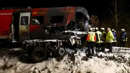 Sejumlah petugas pemadam berada di lokasi kecelakaan kereta penumpang dengan truk milter di persimpangan kereta api di Freihung, Jerman, Kamis (5/11). Sedikitnya satu orang tewas dan beberapa lainnya terluka. (REUTERS / Michaela Rehle)