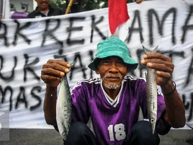 Nelayan menunjukan ikan saat menggelar aksi Tolak Reklamasi Teluk Jakarta di Depan Istana, Jakarta, Senin (19/9). Dalam aksinya mereka menolak pelaksanaan reklamasi Teluk Jakarta meski pemerintah sepakat melanjutkannya. (Liputan6.com/Faizal Fanani)