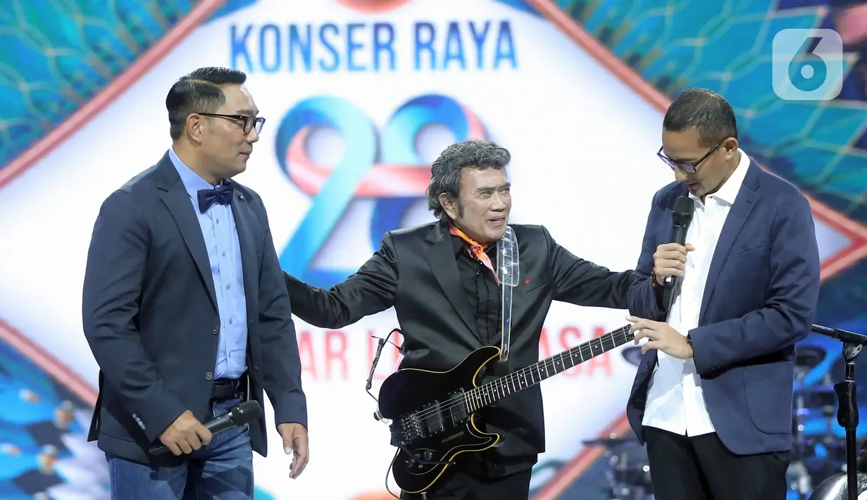 Penyanyi dangdut Rhoma Irama (tengah) berbincang bersama Menteri Pariwisata dan Ekonomi Kreatif Sandiaga Uno (kanan) dan Gubernur Jawa Barat Ridwal Kamil (kiri) pada acara HUT ke-28 Indosiar di Studio 6 EMTEK City, Jakarta, Rabu (11/1/2023). Rhoma Irama membawakan lagu berjudul "Butter" dari BTS dan duet bareng Sandiaga Uno serta Ridwan Kamil saat membawakan lagu berjudul "275 Juta". (Fimela.com/Bambang E. Ros)