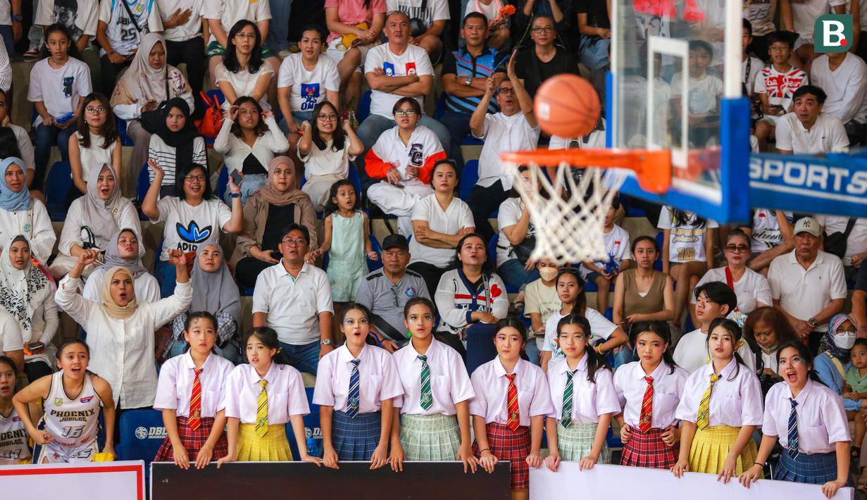 Pendukung SMA Jubilee Jakarta yang diisi oleh guru, murid, orang tua, dan keluarga menyaksikan laga 16 besar DBL 2023/2024 Seri Jakarta Utara dan Jakarta Pusat melawan SMA Budi Mulia Jakarta di GOR Cempaka Putih, Jakarta Pusat, Minggu (13/08/2023). (Bola.com/Bagaskara Lazuardi)