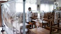 Petugas menyiapkan ruangan kelas yang akan digunakan di SMP N 115 Jakarta, Jumat (21/5/2021). Seleksi PPDB DKI Jakarta tahun ini akan dibagi menjadi empat bagian yakni jalur prestasi, jalur afirmasi, jalur zonasi, dan jalur pindah tugas orangtua dan anak guru. (Liputan6.com/Faizal Fanani)