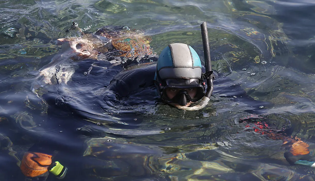 Salem Abu Amerah menyelam berusaha menangkap ikan di laut di pelabuhan  Kota Gaza (20/12/2019). Salem Abu Amerah mencari ikan untuk membantu keluarganya. (AP Photo/Hatem Moussa)