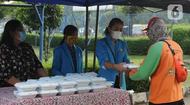 Sejumlah mahasiswa memberikan makanan gratis kepada masyarakat di Universitas Kristen Indonesia (UKI), Cawang, Jakarta, Selasa (16/3/2021). Kegiatan berbagi makanan gratis yang dilakukan oleh civitas akademi UKI itu diselenggarakan selama tiga bulan. (Liputan6.com/Herman Zakharia)