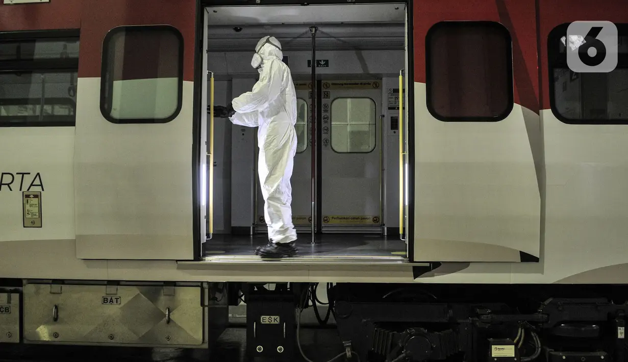 Petugas berkostum alat pelindung diri mengoperasikan sinar ultraviolet (UV) untuk sterilisasi rangkaian kereta Light Rail Transit (LRT) Jakarta di Depo LRT Kelapa Gading, Senin (29/6/2020). Teknologi sinar UV dimanfaatkan untuk sterilisasi kereta dari paparan Covid-19. (merdeka.com/Iqbal Nugroho)