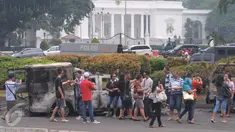 Sejumlah warga melihat mobil aparat yang dibakar demonstran 4 November di kawasan Monas, Jakarta, Sabtu (5/11). Pengunjung menjadikan dua kendaraan milik kepolisian tersebut sebagai objek foto dan melakukan swafoto. (Liputan6.com/Angga Yuniar)