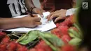 Pedagang buah rambutan mengisi surat pernyataan saat ditindak oleh Petugas Dinas Perhubungan di CFD di kawasan Bunderan HI, Jakarta, Minggu (4/2). (Liputan6.com/Faizal Fanani)