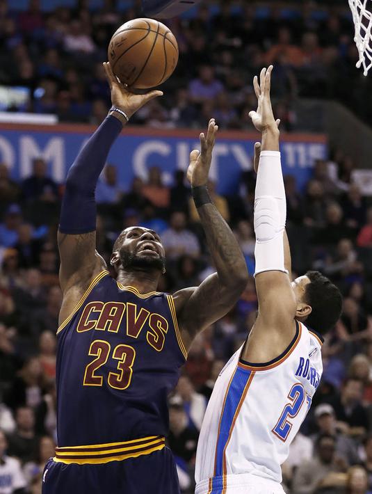 Pebasket Cleveland Cavaliers, LeBron James, dihadang pebasket Oklahoma City Thunder, Andre Roberson. Pada laga ini LeBron hanya mampu mencetak 18 poin. (EPA/Larry W.Smith)