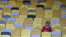 Seorang fans Manchester United duduk di tribune yang kosong dalam laga persahabatan melawan ASEAN All-Stars yang berlangsung di Stadion Bukit Jalil, Malaysia, pada hari Rabu (28/5/2025) malam waktu setempat. (AFP/Mohd Rasfan)