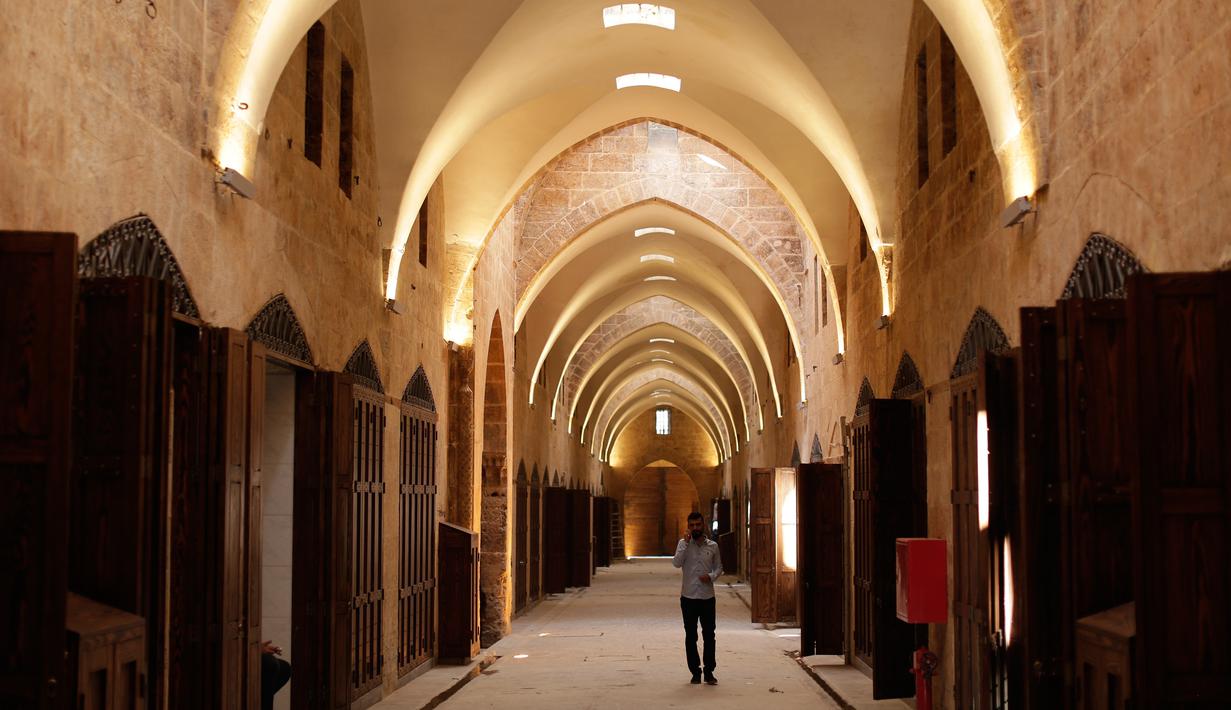 Seorang pria berjalan di Pasar al-Saqatiyah yang baru saja direnovasi, Kota Tua Aleppo, Suriah, Sabtu (27/7/2019). Kegiatan ekonomi perlahan mulai tumbuh tiga tahun setelah pertempuran besar terjadi di Aleppo. (AP Photo/Hassan Ammar)