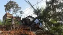 Seorang warga membawa tempat tidur kayu yang dibongkar setelah tanah longsor akibat hujan lebat di Belo Horizonte, Brasil (27/1/2020). Lebih dari 30.000 orang terlantar akibat hujan lebat di Brasil tenggara yang juga menewaskan lebih dari 50 orang. (AP Photo/Gustavo Andrade)