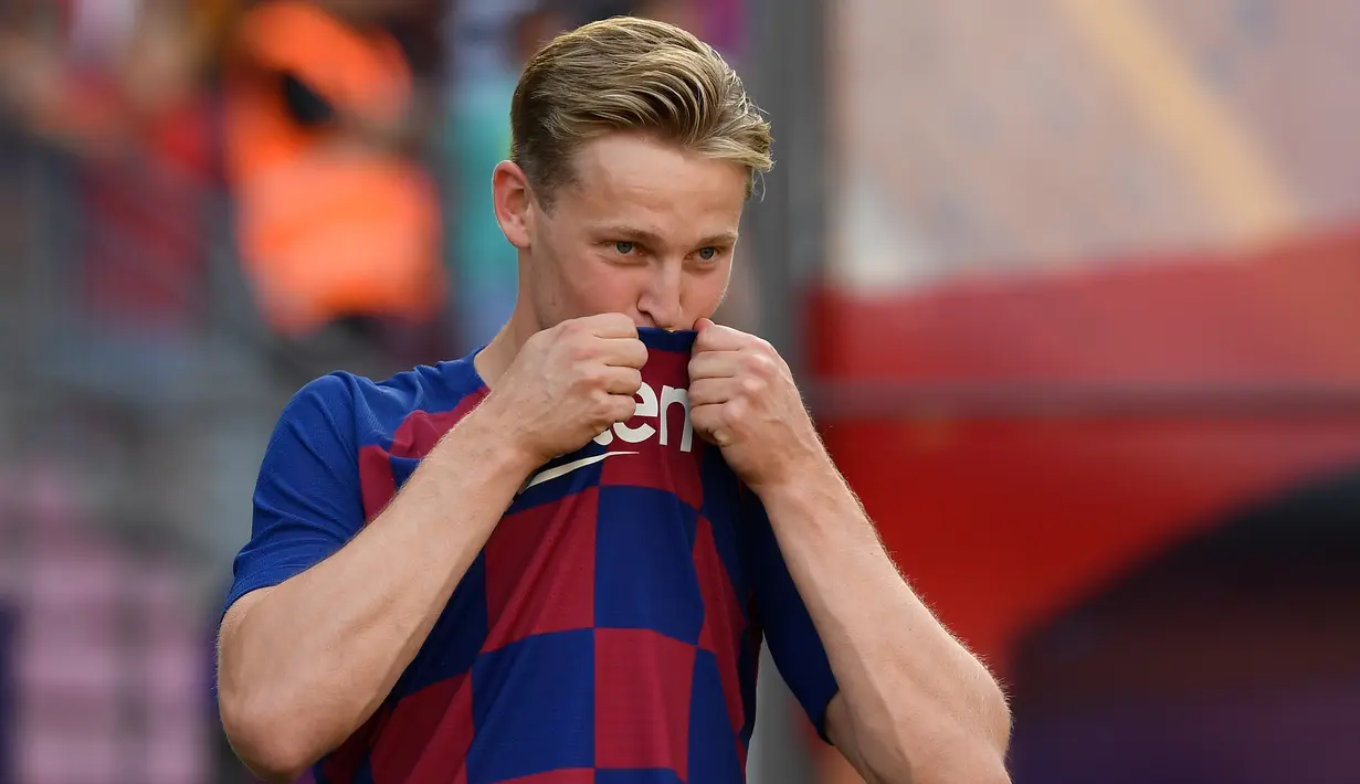 Gelandang asal Belanda Frenkie de Jong mencium logo klub barunya saat pengenalan dirinya sebagai pemain Barcelona di stadion Camp Nou, Spanyol (5/7/2019). Frenkie de Jong sangat antusias bisa bermain dengan sang superstar, Lionel Messi. (AFP Photo/Lluis Gene)