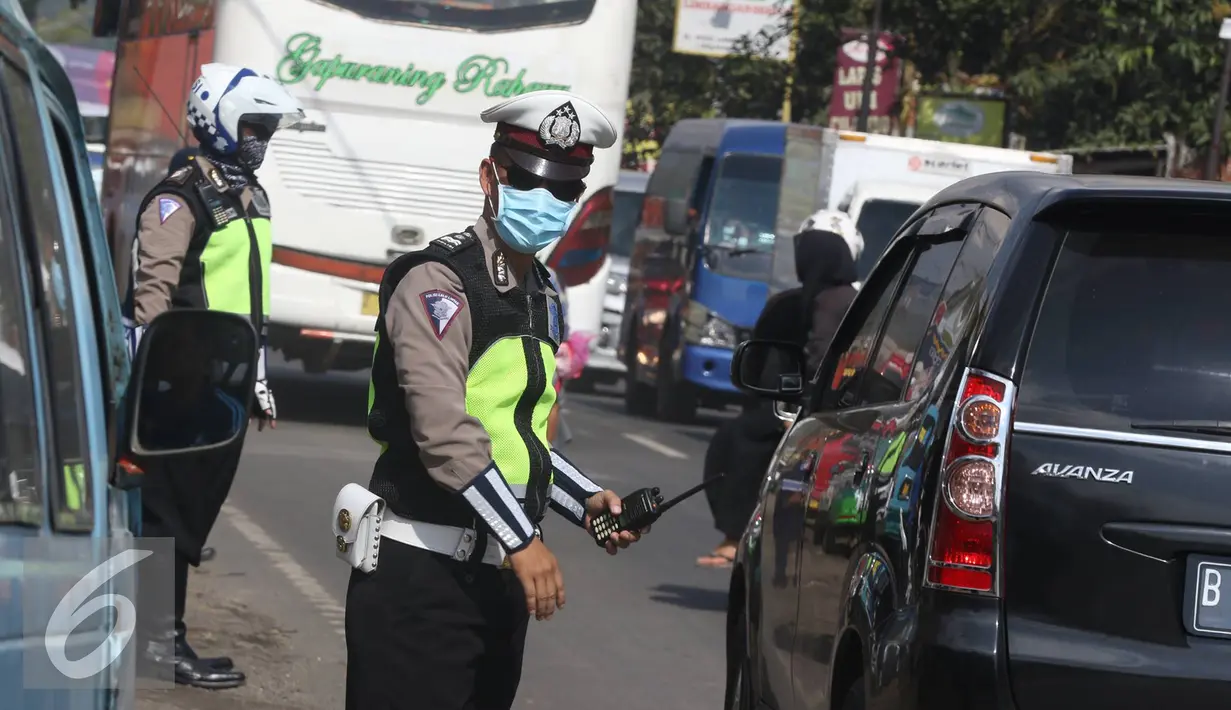 Petugas mengatur lalu lintas di sepanjang Simpang Cagak Nagreg, Jawa Barat, Minggu (3/7).H-3 menjelang lebaran volume kendaraan yang melintas meningkat ditambah dengan aktivitas pasar yang ada di kawasan tersebut. (Liputan6.com/Immanuel Antonius)