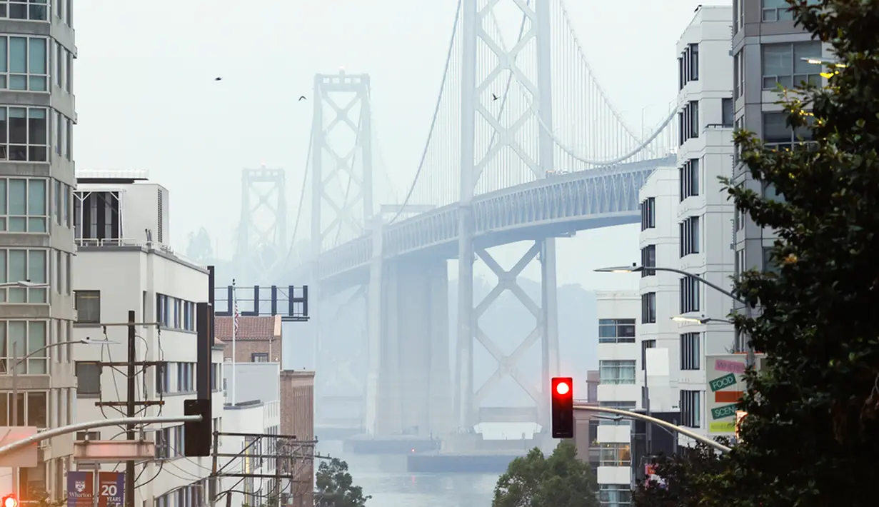 Asap sangat tebal pada hari Rabu sehingga Jembatan Teluk San Francisco hampir tidak terlihat dari garis pantai di sepanjang teluk dan cakrawala San Francisco hampir tidak terlihat di seberang teluk dari Pelabuhan Oakland. (Jessica Christian/San Francisco Chronicle via AP)