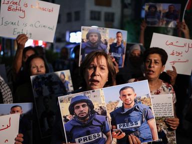 Para demonstran memegang foto dan spanduk yang mengecam pembunuhan jurnalis Al Jazeera dalam serangan Israel di Kota Gaza, selama aksi doa bersama di Ramallah, di Tepi Barat yang diduduki pada 11 Agustus 2025. (Zain JAAFAR/AFP)