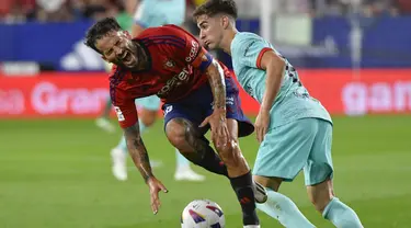 Gelandang Osasuna, Ruben Garcia dilanggar oleh gelandang Barcelona Gavi pada pekan keempat La Liga Spanyol di stadion Pamplona, Senin (4/9/2023). (AP Photo/Alvaro Barrientos)