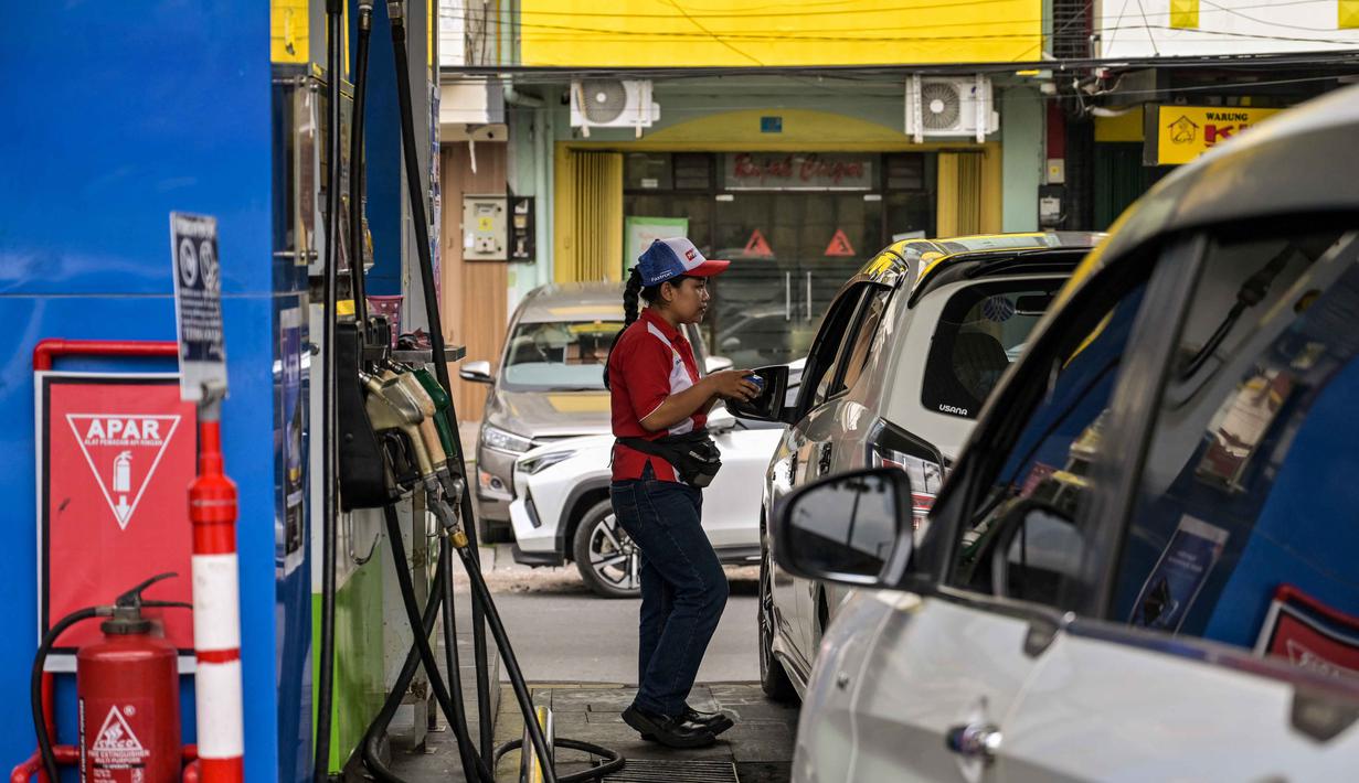 Serangan tersebut memicu aksi balasan keras dari pemerintah Iran. Tampak dalam foto, seorang karyawan mengisi bensin di sebuah Stasiun Pengisian Bahan Bakar Umum (SPBU) di Surabaya, Jawa Timur, pada Senin 9 Maret 2026. (JUNI KRISWANTO/AFP)