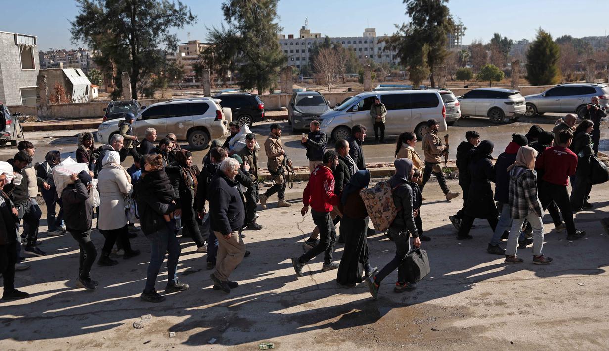 Evakuasi warga ini akibat eskalasi bentrokan antara Tentara Pemerintah Suriah dan Pasukan Demokratik Suriah (SDF). Tampak dalam foto, warga lingkungan Sheikh Maqsud dievakuasi dari zona berbahaya oleh anggota pasukan keamanan pemerintah Suriah, di Aleppo pada Sabtu 10 Januari 2026. (OMAR HAJ KADOUR/AFP)