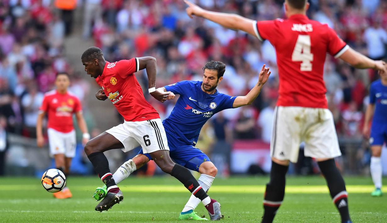 Gelandang Manchester United, Paul Pogba, berebut bola dengan gelandang Chelsea, Cesc Fabregas, pada laga final Piala FA 2017-2018 di Stadion Wembley, Sabtu (19/5/2018). Chelsea menang 1-0 atas Manchester United. (AFP/Glyn Kirk)