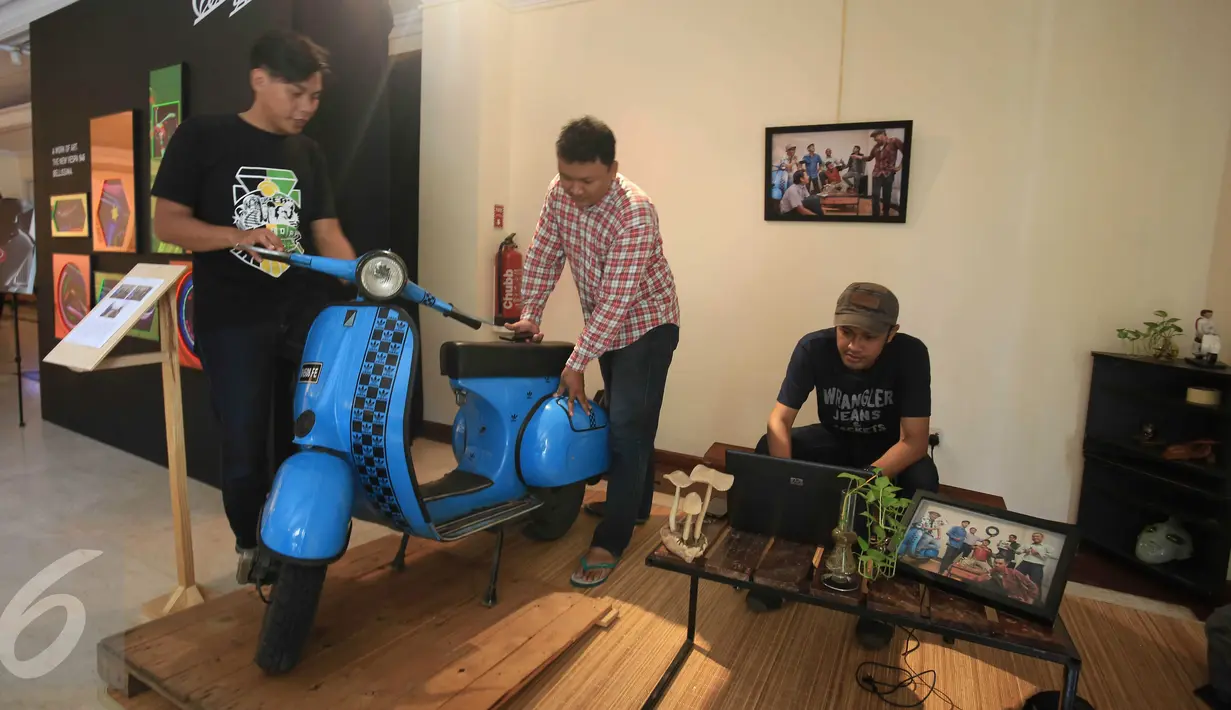 Pengunjung melihat motor pada pameran fotografi "La vespa, Un Mito : Storia e Storie" di Istituto Italiano, Cultura, Jakarta, (20/1). Kedutaan besar italia untuk Indonesia turut membantu dalam berlangsungnya pameran ini. (Liputan6.com/Angga Yuniar)