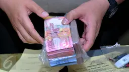 Barang bukti berupa uang senilai Rp.45 Juta diamankan Polda Metro Jaya dari oknum pegawai perpajakan, Jakarta, Kamis (17/12/2015). Tersangka mengemplang pajak dari tiga hotel wajib pajak di kawasan Kembangan, Jakarta Barat. (Liputan6.com/Gempur M Surya)