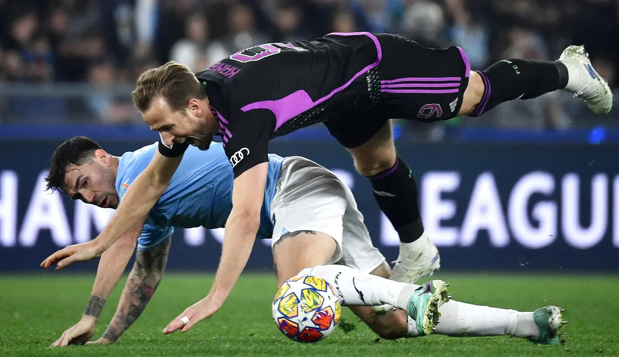 Pemain Bayern Munchen, Harry Kane (atas) terjatuh saat berebut bola dengan pemain Lazio, Alessio Romagnoli pada laga leg pertama 16 besar Liga Champions 2023/2024 di Olympic Stadium, Roma, Italia, Kamis (15/02/2024) WIB. (AFP/Filippo Monteforte)
