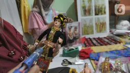 Ibu rumah tangga menyelesaikan pembuatan boneka adat Indonesia di Ammie Dolls di Komplek Pondok Tirta, Depok, Kamis (13/08/2020). Pada masa pandemi ini produksi dan penjualan anjlok hingga 95 persen menyebabkan perajin beralih ke bidang lain untuk mencukupi kebutuhan hidup. (merdeka.com/Arie Basuki)