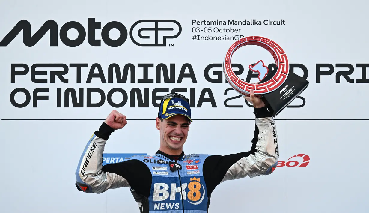 Pembalap MotoGP Spanyol tim BK8 Gresini Racing, Fermin Aldeguer, merayakan kemenangan di podium usai menjuarai balapan MotoGP Indonesia 2025 di Sirkuit Mandalika, Lombok, pada Minggu (5/10/2025). (AFP/Sonny Tumbelaka).