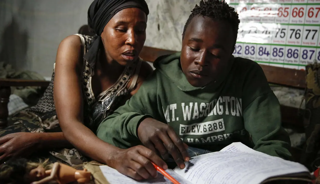 Miriam Nyambura mengajari putranya Peter Kihika, 16, yang ingin menjadi guru tetapi sekarang bekerja pada siang hari memulung sampah di TPA terbesar di Kenya, setelah ibunya kehilangan pekerjaan dan sekolahnya ditutup karena pandemi corona, di Nairobi, 26 September 2020. (AP Photo/Brian Inganga)