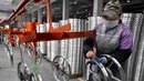 Seorang pekerja wanita mengecek kondisi pelek di pabrik pembuatan pelek sepeda motor di Jinhua, Provinsi Zhejiang, China (14/1). (AFP Photo/China Out)