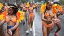 Penari karnaval menari di tengah hujan selama parade hari pertama Karnaval Notting Hill di London barat, Minggu (26/8). Karnaval Notting Hill yang merupakan pawai jalanan terbesar di Eropa diadakan setiap tahun sejak tahun 1966. (AFP/Daniel LEAL-OLIVAS)