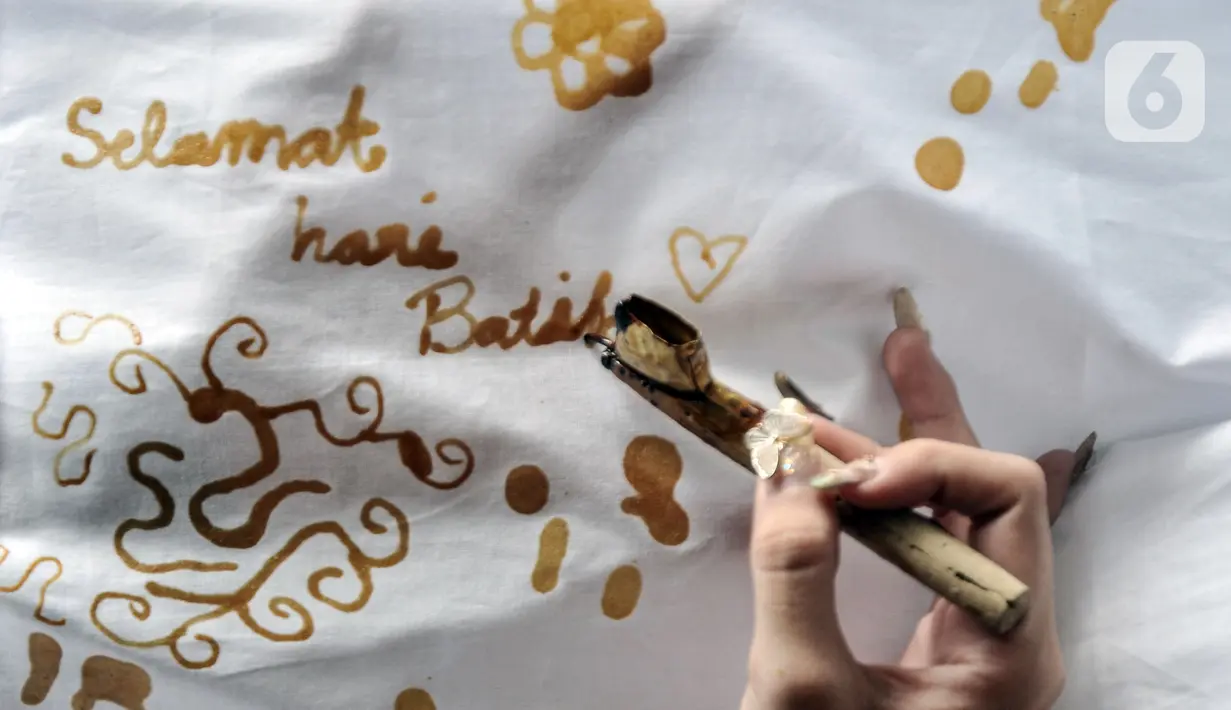 Pengunjung belajar membatik di Rumah Batik Palbatu, Jakarta, Minggu (2/10/2022). Dalam rangka memeriahkan Hari Batik Nasional, Rumah Batik Palbatu menggelar pelatihan membatik kepada masyarakat umum sebagai upaya meningkatkan minat terutama bagi generasi milenial dalam melestarikan seni kriya tersebut. (merdeka.com/Iqbal S. Nugroho)