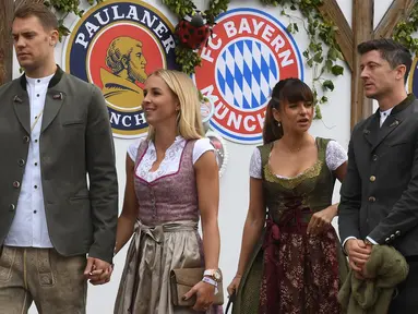 Kiper Bayern Munchen, Manuel Neuer bersama istrinya Nina Neuer dan striker Robert Lewandowski dan istrinya Anna Lewandowska tiba menghadiri festival bir Oktoberfest 2019 di Munich, Jerman selatan (6/10/2019). (AFP Photo/Christof Stache)