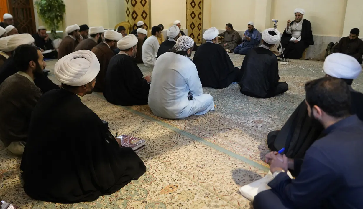 Ulama Syiah mendengarkan guru mereka di kota suci Najaf, Irak, 23 November 2021. Sekolah-sekolah agama di Irak kembali dibuka setelah lebih dari dua tahun di tengah pandemi COVID-19. (Qassem al-KAABI/AFP)